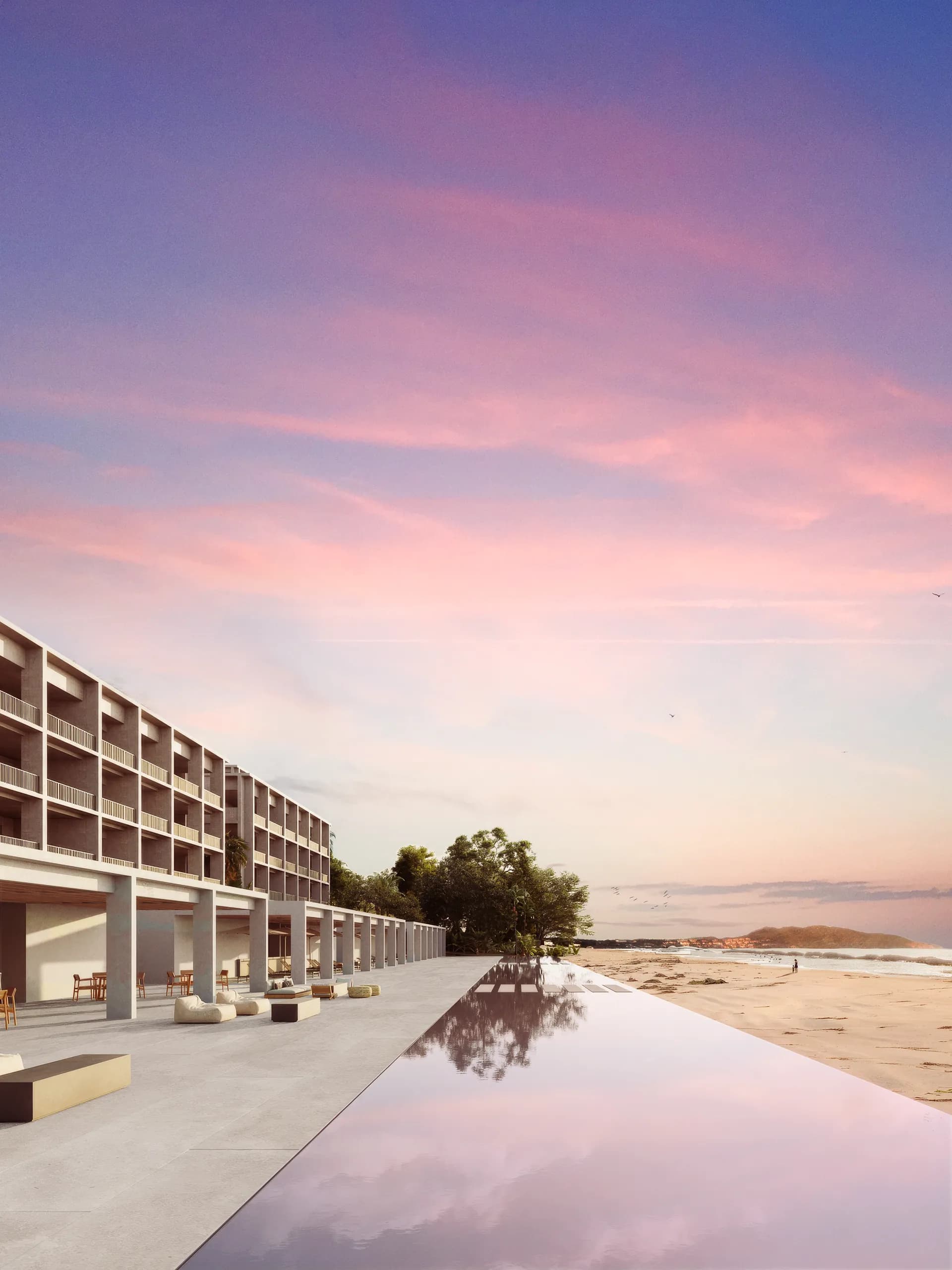 UAVI beachfront infinity pool overlooking the Pacific Ocean at sunset, with contemporary architecture and direct beach access