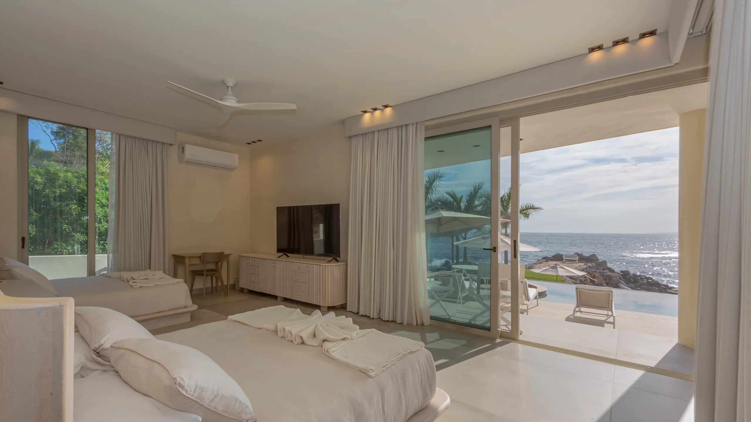 Private bedroom suite with direct terrace access and uninterrupted views toward the Pacific coastline.