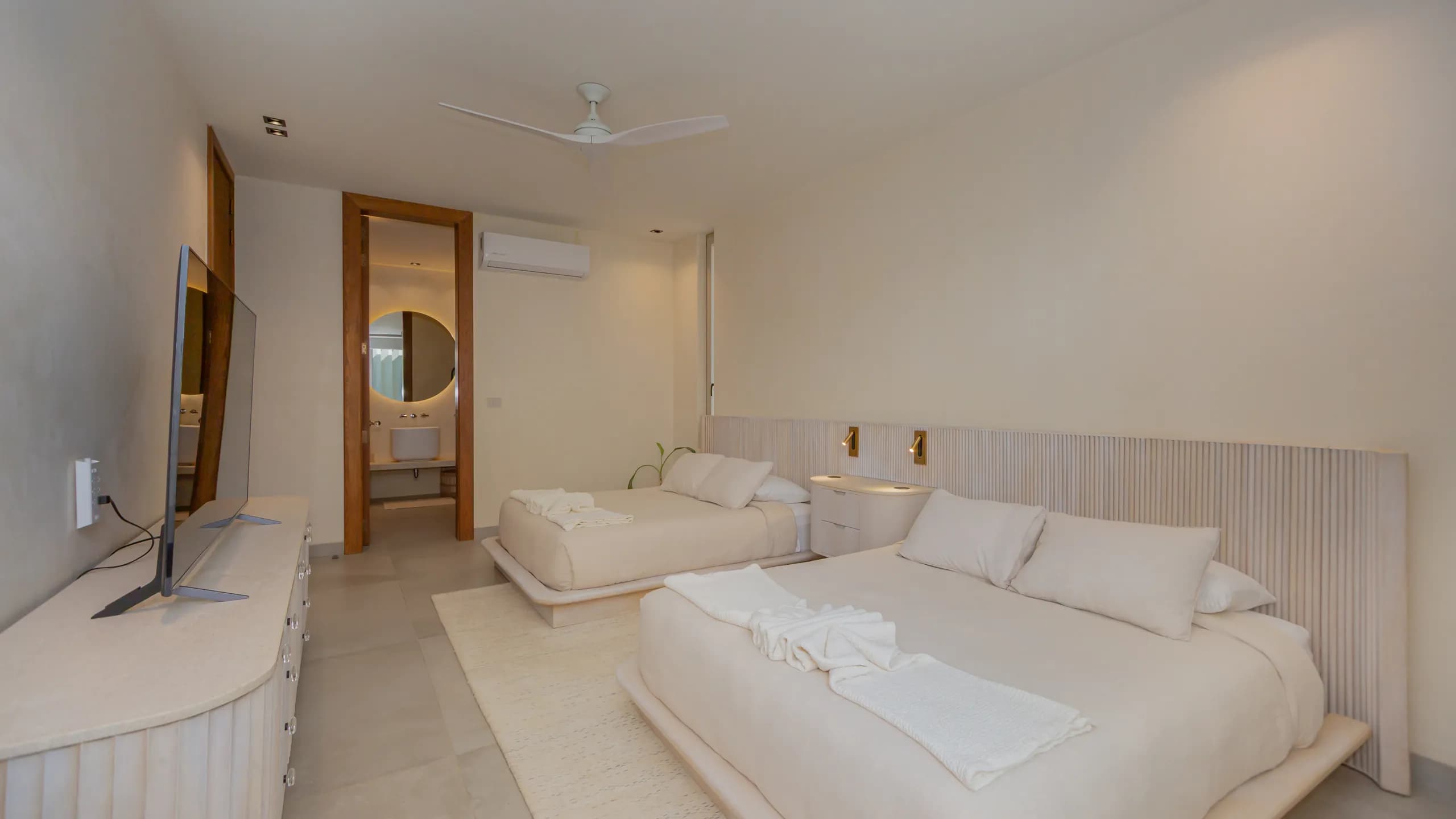 Guest accommodations designed with soft neutral tones, natural light, and a calm minimalist aesthetic.