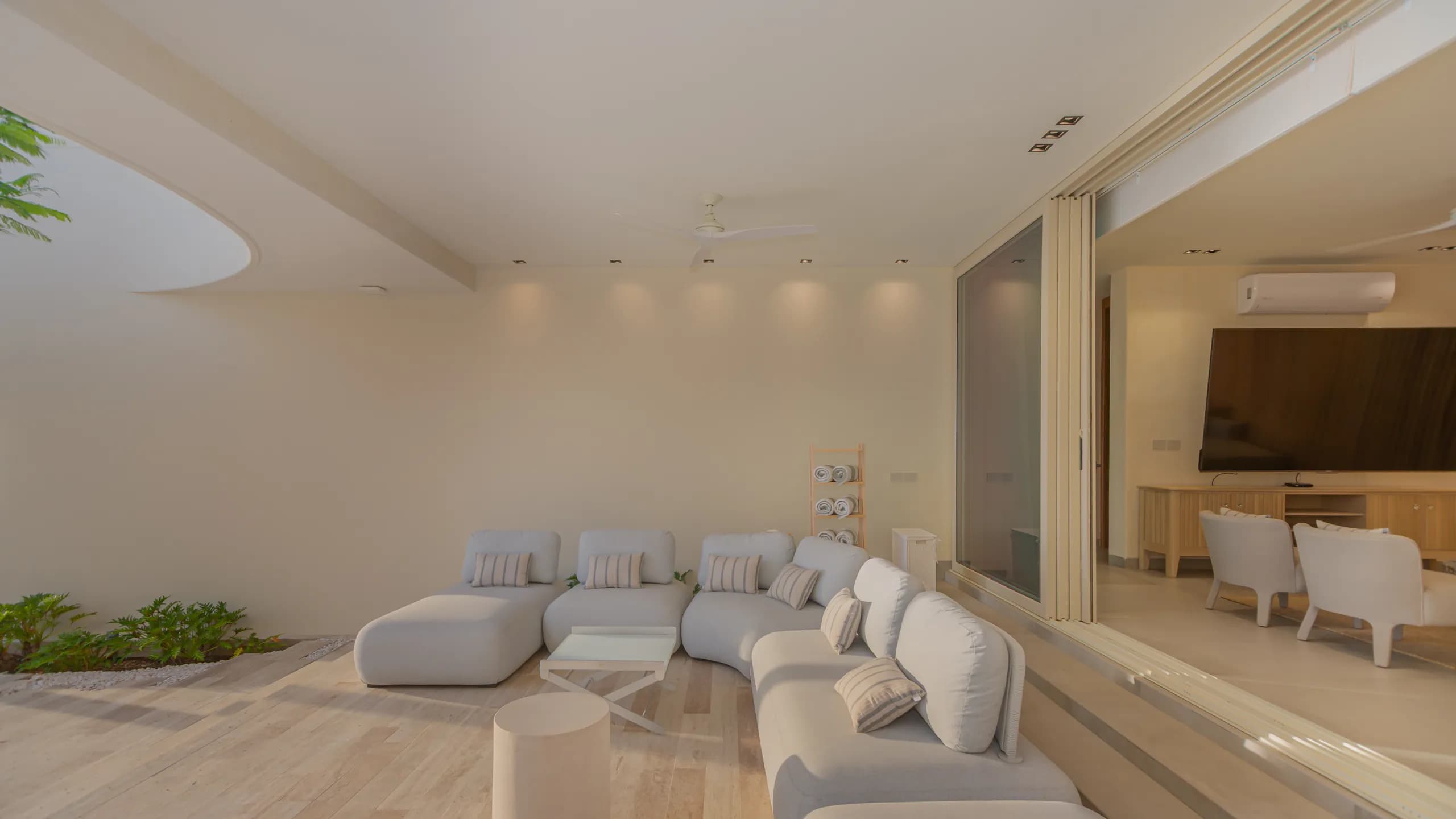 Covered outdoor lounge seamlessly connected to the interior living spaces, designed for year-round oceanfront entertaining.