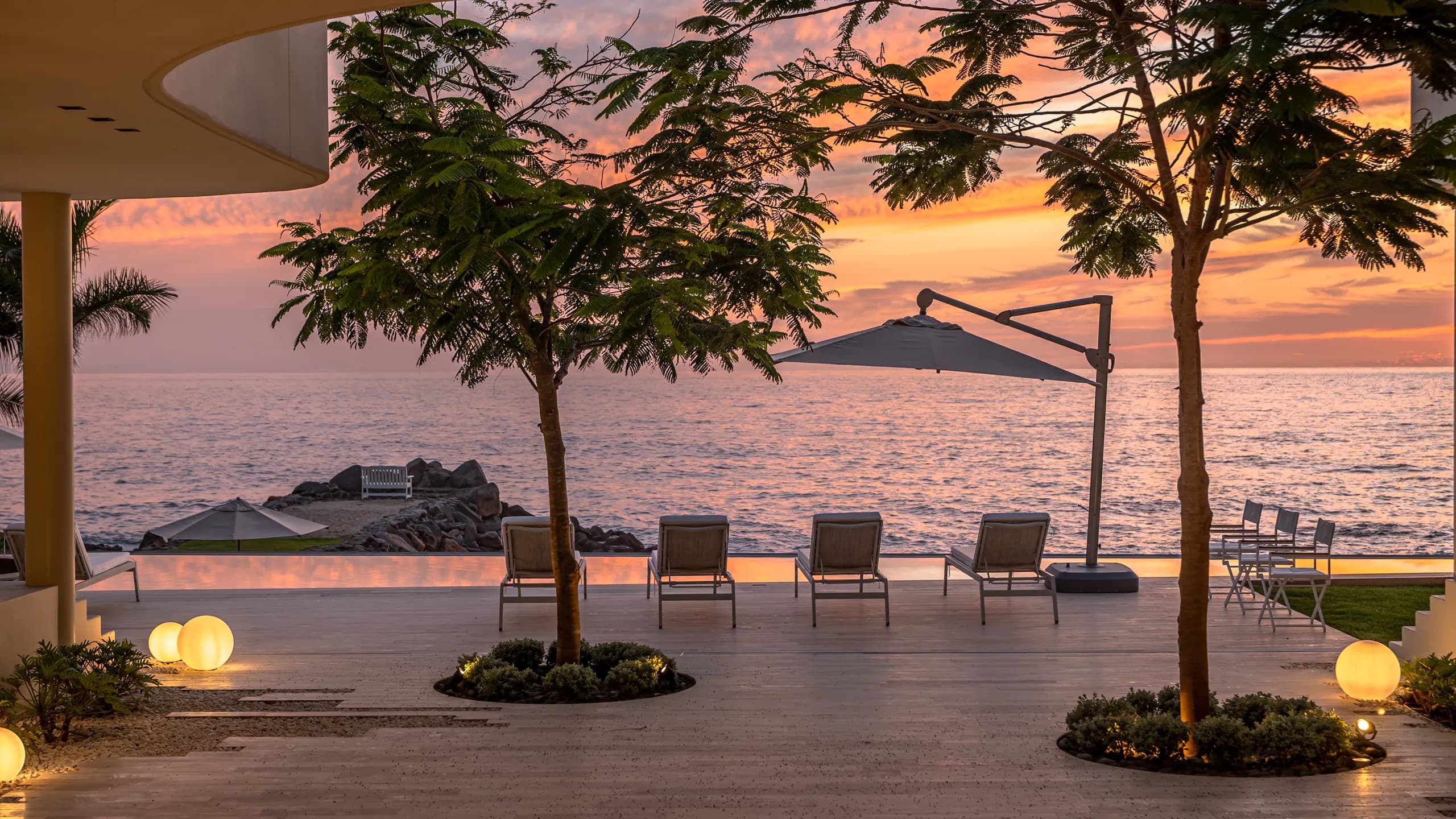 Evening oceanfront atmosphere designed for quiet moments, open-air living, and panoramic sunset views over the Pacific.