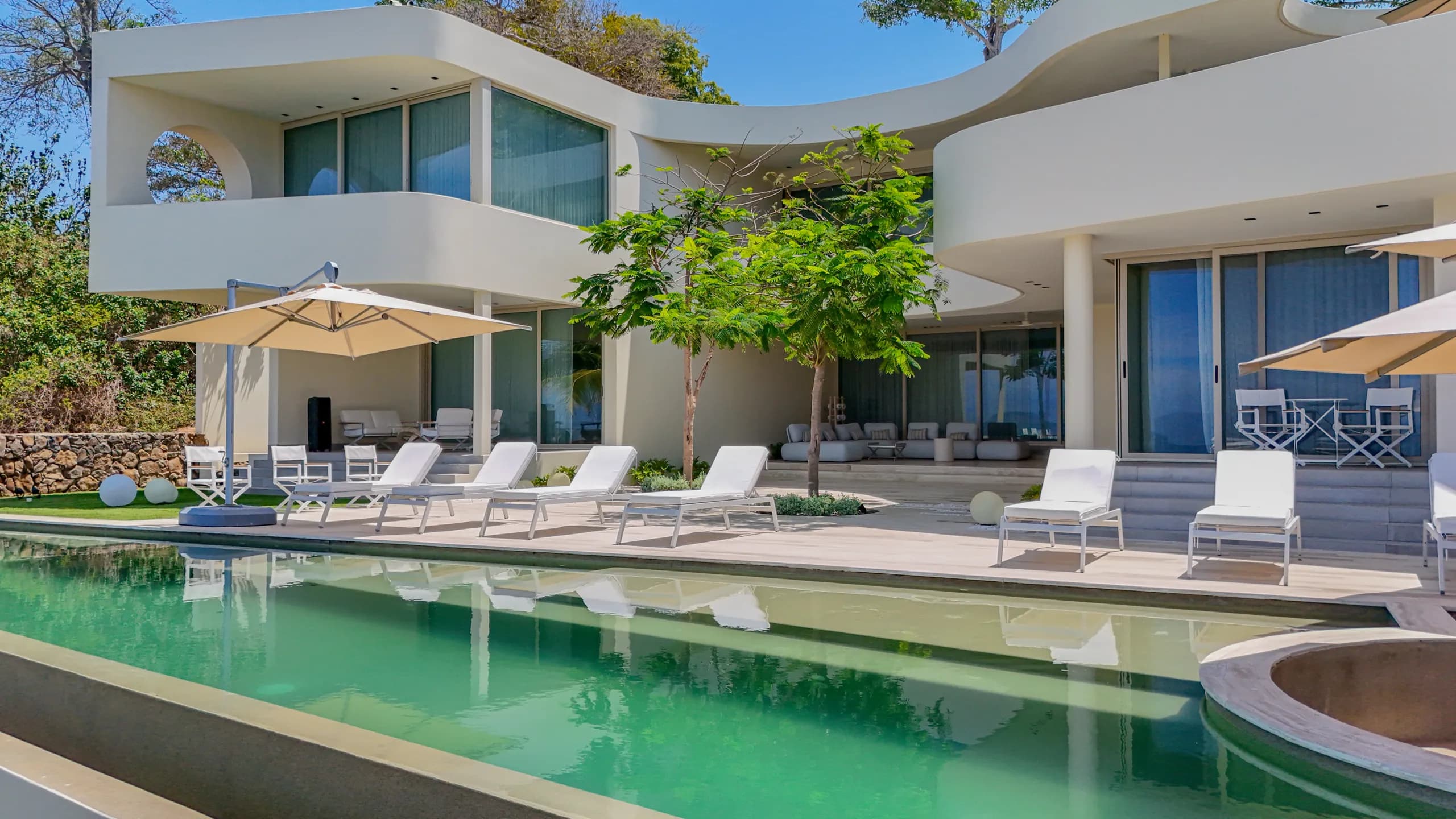 Contemporary forms, expansive glazing, and carefully designed outdoor spaces define the residence’s architectural identity.
