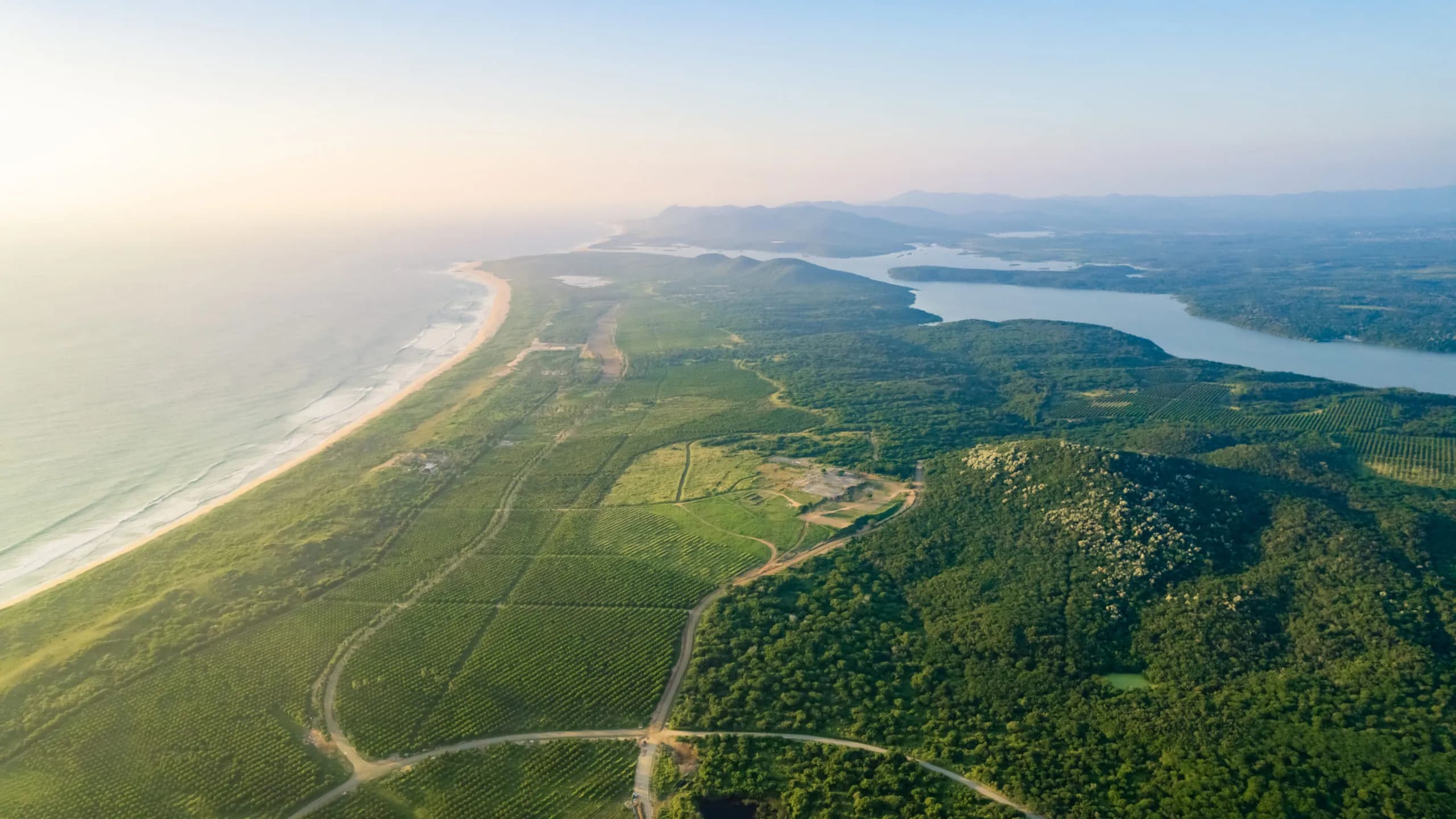 Aerial view of coastal land with ocean frontage, natural landscapes, and development potential